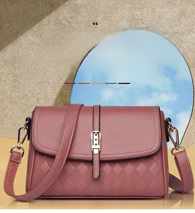 Detail view of pink leather crossbody bag with quilted patterns and gold metal buckle