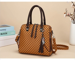 Close-up of vintage brown patterned handbag with a cat tassel charm and floral accents