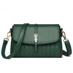 Close-up of dark green crossbody bag featuring litchi texture and diamond quilt pattern