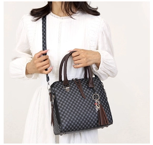 Fashionable checkered tote bag with brown handles and a cute cat tassel charm detail