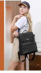 Detail of black faux leather backpack with quilted diamond patterns and gold studs