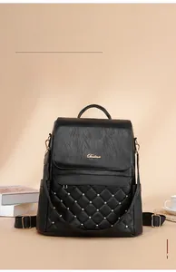 Detail of vintage black leather backpack with quilted diamond patterns and gold studs