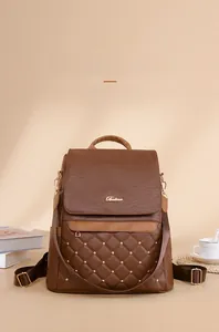 Brown leather backpack detail with quilted diamond pattern and gold rivets in a cozy setting