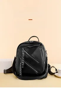 Detail shot of black PU leather backpack with decorative diagonal zippers and rivets