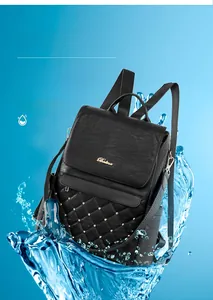 Close-up of black quilted faux leather backpack with gold studs and waterproof feature