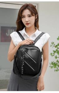 Detail of black PU leather backpack showing silver zippers and rivet decorative pulls