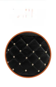 Close-up of black quilted leather backpack featuring gold stud accents and stitching