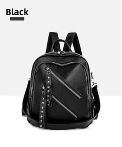 Close-up of black PU leather backpack with diagonal zippers and metal rivet strap detail