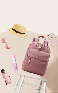Pink nylon backpack for travel with colorful accessories and large main compartment