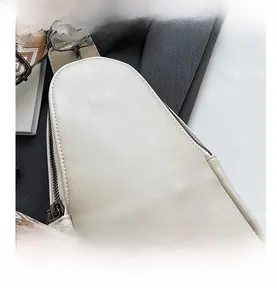 Close-up of cream PU leather texture and durable metal zipper on a versatile chest bag