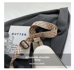 Detail view of adjustable geometric pattern wide strap on beige PU leather crossbody bag