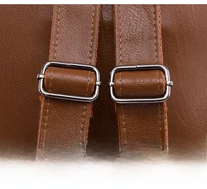 Detail of adjustable brown PU leather shoulder strap with metallic buckle and stitching