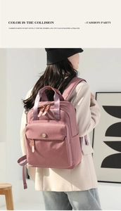 Detail of mauve nylon backpack showing leather strap accents and front magnetic pocket