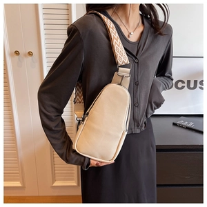 Close-up of cream PU leather crossbody bag with geometric pattern wide woven strap