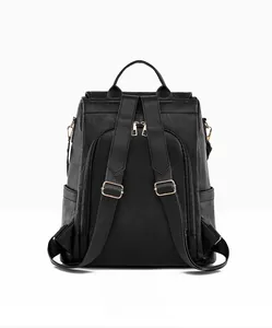 Back view of black leather backpack with soft pebble texture and golden zippers