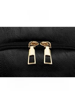 Close-up of golden dual zippers on black lychee texture faux leather backpack detail
