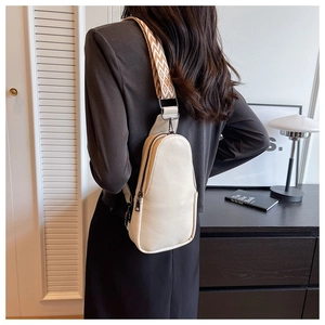 Detail of cream PU leather chest bag with decorative geometric woven shoulder strap