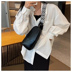 Close-up of black PU leather crossbody bag with geometric pattern wide shoulder strap
