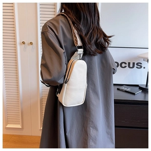 Back view of model wearing a white PU leather crossbody bag with geometric woven strap
