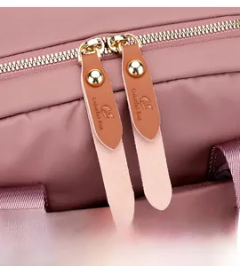 Detail of smooth metal zippers and premium nylon texture on the pink travel backpack