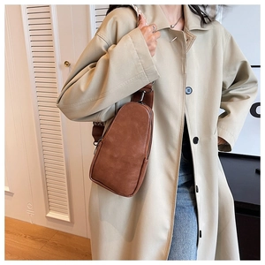 Brown PU leather chest bag with a geometric pattern strap worn by a model in a beige coat