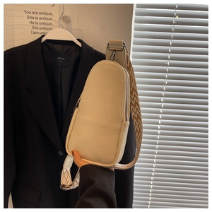 Detail of cream PU leather teardrop chest bag with geometric woven wide shoulder strap