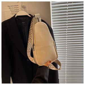 Detail of beige PU leather crossbody bag with geometric woven strap and metal zipper