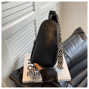 Detail of black PU leather chest bag featuring a stylish black and white geometric strap
