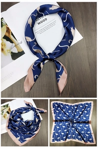 Detail of navy blue square silk scarf with pink flamingo print and hand-rolled edges
