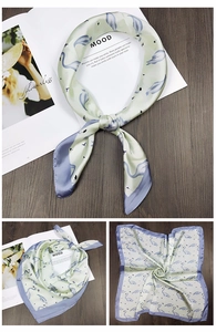 Detail of square silk scarf with mint green flamingo print and contrasting borders