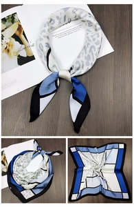Detail view showing blue and grey leopard print silk scarf with geometric color block design