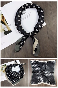 Detail of silk square scarf featuring elegant horse print on luxury wood texture