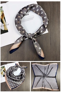 Detail view of grey silk square scarf featuring horse head prints and contrast hem edges