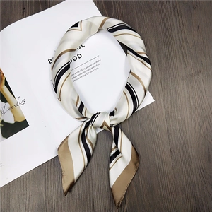 Modern geometric silk-texture scarf with brown and white stripes on magazine