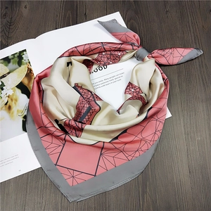 Detail of a silky square scarf with Eiffel Tower geometric print on a fashion magazine