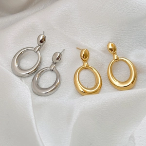 Boucles d'oreilles ovales doubles en or et argent sur fond de soie blanche