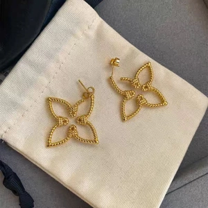 French luxury 18K gold-plated twisted rope floral stud earrings on jewelry pouch