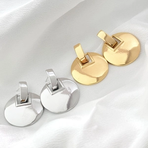 Boucles d'oreilles grands disques dorées et argentées 18 carats sur satin blanc