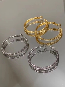 Dettagli di orecchini a cerchio intrecciati in oro 18K e argento con finitura opaca