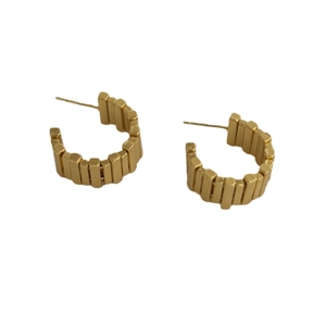 Modern gold geometric C-shaped hoop earrings with a unique tiered architectural texture