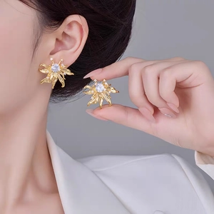 Detail of vintage flower stud earrings with gold plating and sparkling zircon stones