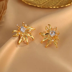 Vintage floral zircon stud earrings in gold finish on elegant champagne silk fabric