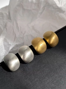 Detailaufnahme minimalistischer Ringe in Gold und Silber mit gebürsteter Metallstruktur