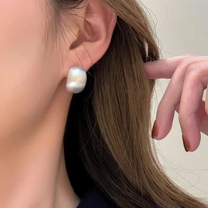 Minimalistische gebürstete Metallohrstecker in Matt-Silber am Ohr des Modells