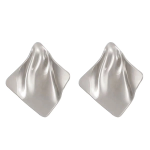 Detailed view of silver square earrings with a modern irregular wrinkled metal texture