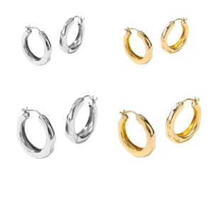 Creolen mit unregelmäßiger Lavatextur in Gold und Silber auf weißem Hintergrund