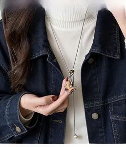 Dettaglio del ciondolo vintage a cavallo a dondolo in legno con strass su catena lunga