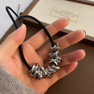 Detail of minimalist black cord necklace featuring interlocking polished silver rings
