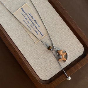 Collana lunga vintage con ciondolo a cavallo in legno, occhio di tigre e perla bianca