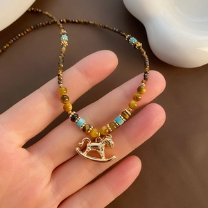 Tiger eye stone bead necklace with a golden rocking horse pendant for women